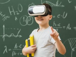 smiley-boy-wearing-virtual-reality-headset-holding-books_23-2148556175